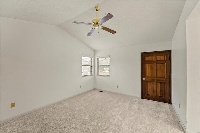 carpeted empty room with ceiling fan and lofted ceiling