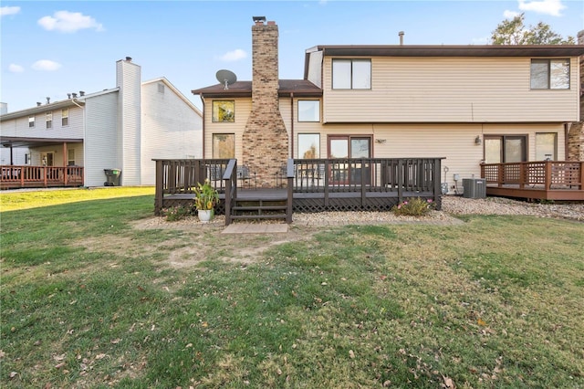 rear view of property featuring a wooden deck, a yard, and central air condition unit