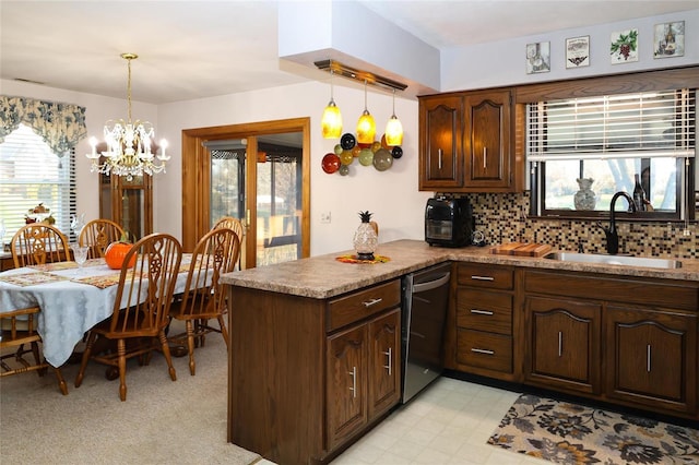 kitchen with a chandelier, pendant lighting, sink, stainless steel dishwasher, and backsplash