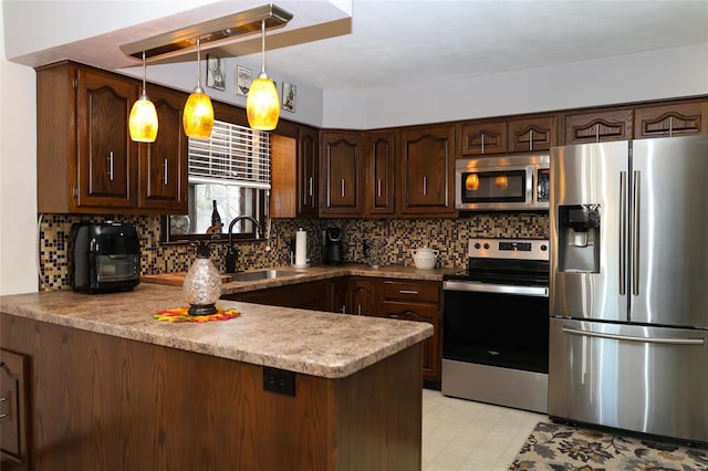 kitchen featuring appliances with stainless steel finishes, hanging light fixtures, kitchen peninsula, decorative backsplash, and dark brown cabinetry