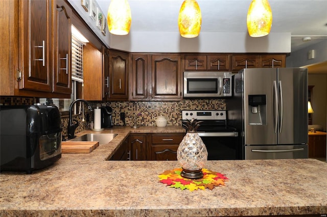 kitchen featuring dark brown cabinets, appliances with stainless steel finishes, tasteful backsplash, and sink