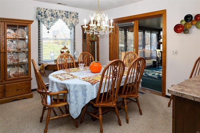 dining space featuring a notable chandelier and light carpet