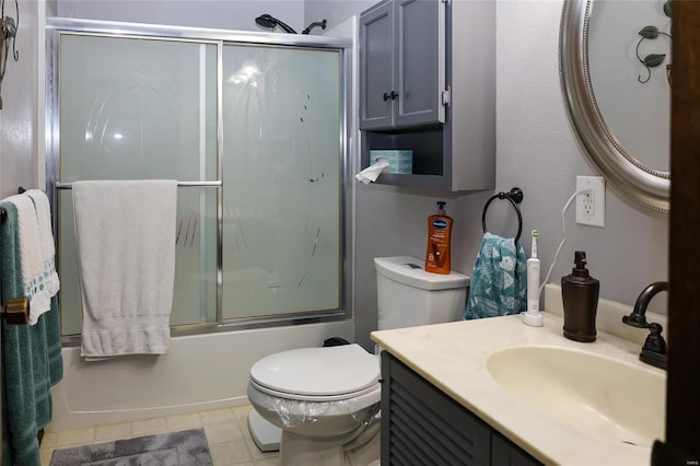 full bathroom featuring combined bath / shower with glass door, vanity, tile patterned floors, and toilet