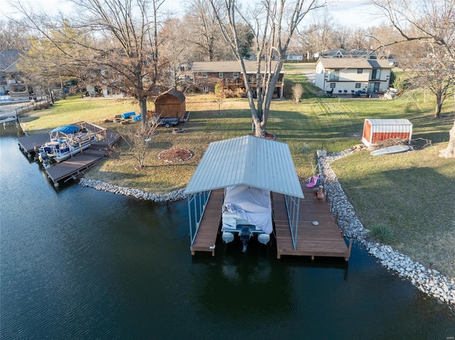 view of dock with a lawn and a water view