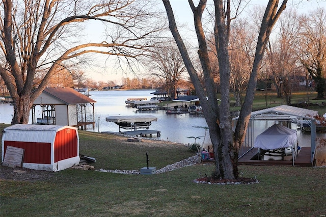 dock area with a lawn and a water view