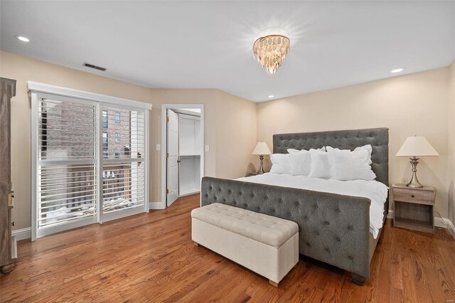 bedroom with hardwood / wood-style flooring, a closet, and a chandelier