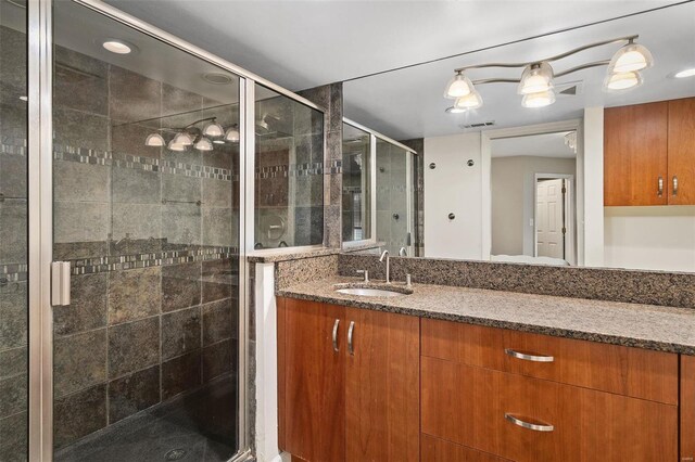 bathroom with a shower with door and vanity