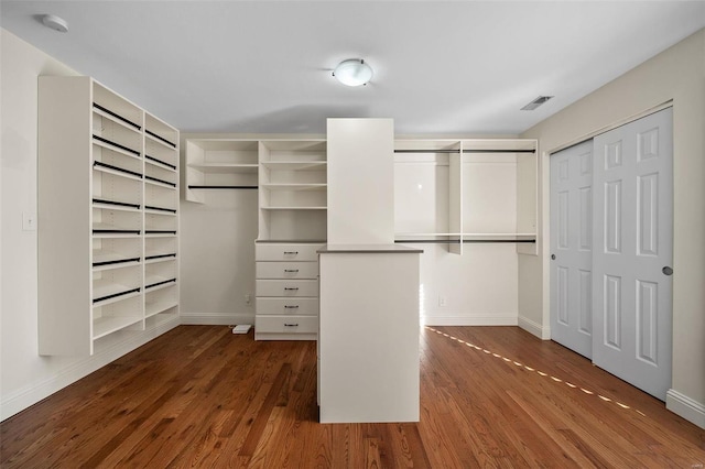 spacious closet with dark wood-type flooring