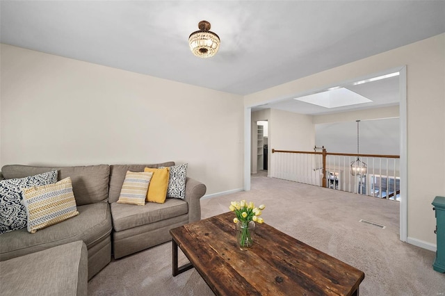 carpeted living room featuring a skylight