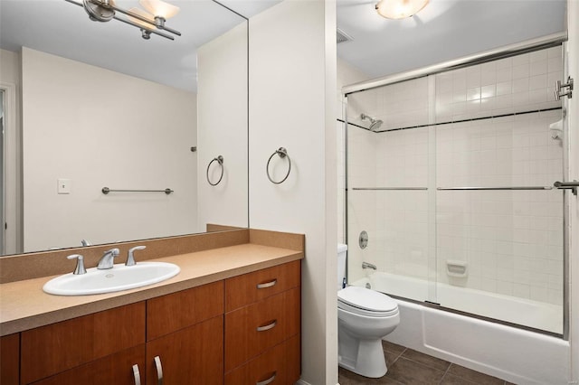 full bathroom with toilet, bath / shower combo with glass door, tile patterned flooring, and vanity