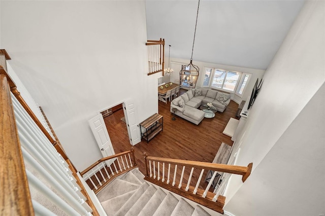 stairway featuring high vaulted ceiling and a notable chandelier