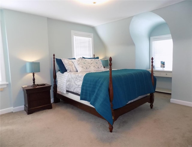 bedroom with lofted ceiling, multiple windows, and carpet