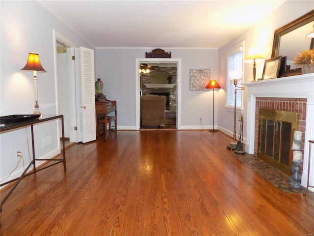 unfurnished living room with hardwood / wood-style floors, crown molding, and a fireplace