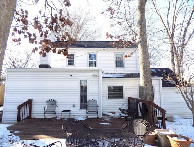 snow covered rear of property featuring a deck