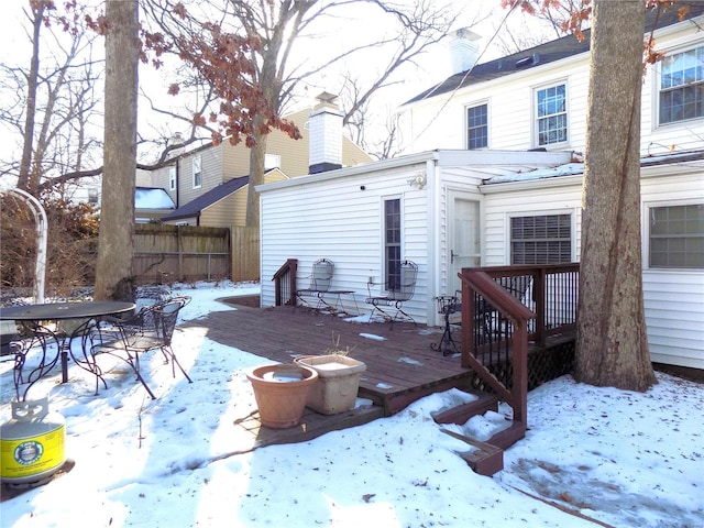 snow covered house with a deck