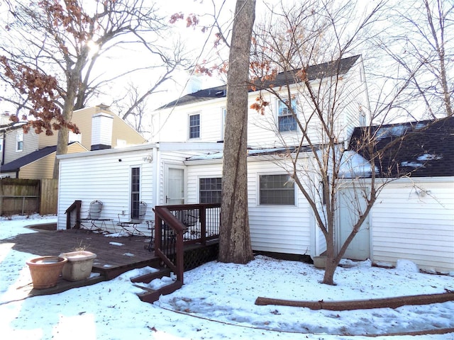 snow covered house with a deck