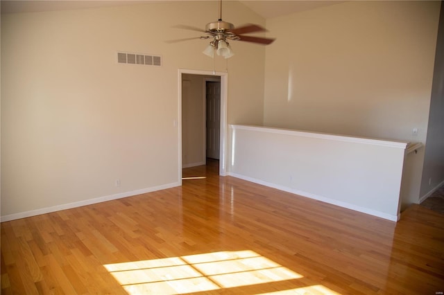 spare room with ceiling fan, light wood-type flooring, and vaulted ceiling