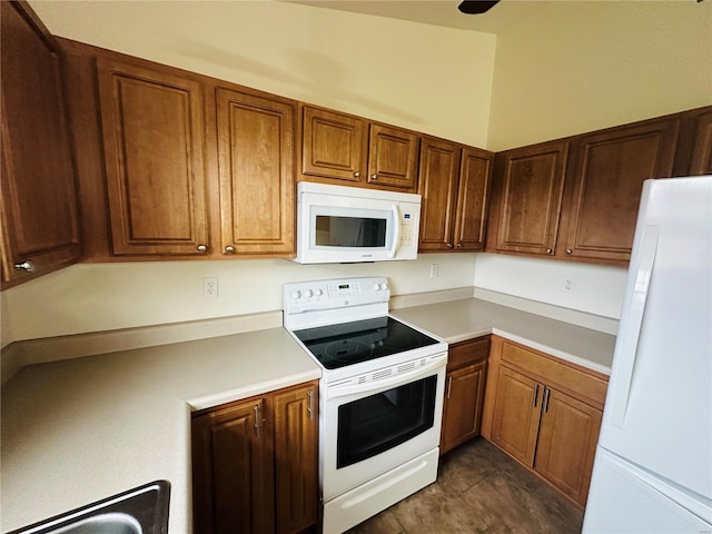 kitchen featuring dark tile patterned flooring and white appliances