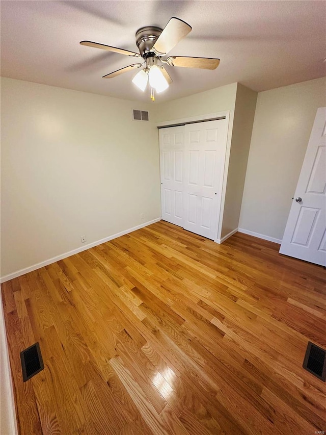 unfurnished bedroom featuring ceiling fan, a closet, and hardwood / wood-style floors