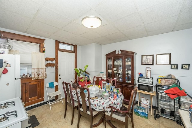 dining area featuring a drop ceiling