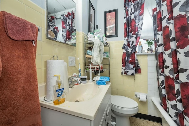 full bathroom with shower / tub combo, vanity, toilet, and tile walls