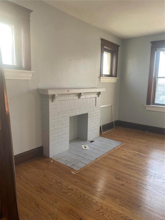 unfurnished living room featuring a fireplace, plenty of natural light, and hardwood / wood-style flooring