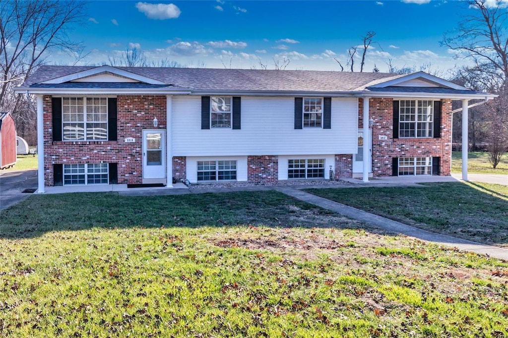 raised ranch featuring a front lawn