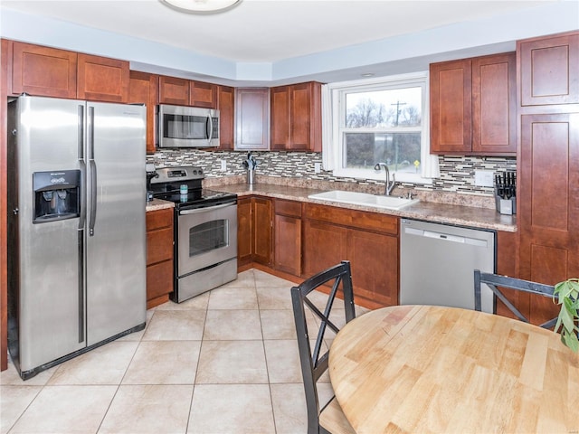 kitchen featuring light stone countertops, appliances with stainless steel finishes, tasteful backsplash, and sink