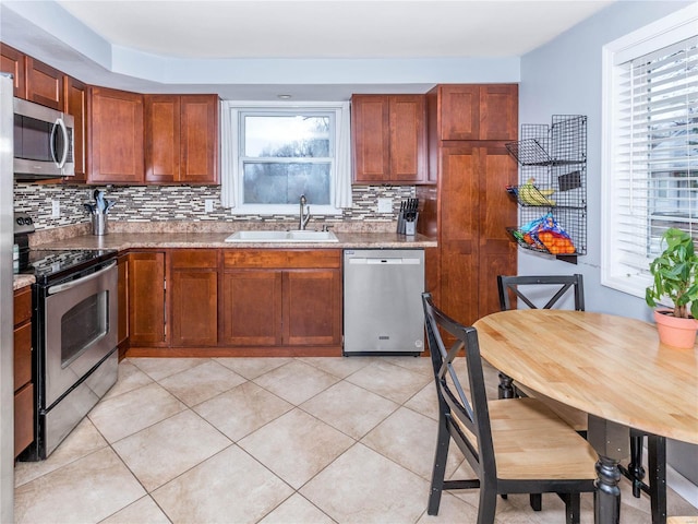 kitchen with a healthy amount of sunlight, light tile patterned floors, sink, and appliances with stainless steel finishes