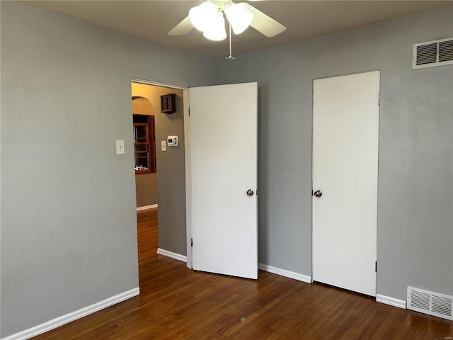 unfurnished bedroom featuring dark hardwood / wood-style floors and ceiling fan