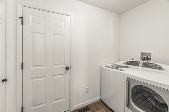 washroom with dark hardwood / wood-style floors and washing machine and clothes dryer