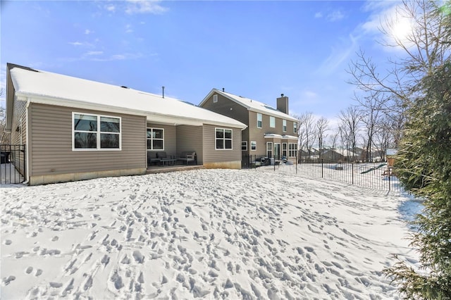 view of snow covered rear of property