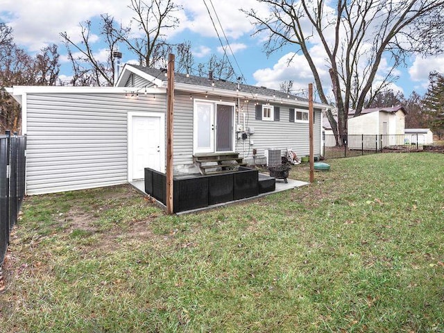 rear view of property featuring a yard and central air condition unit