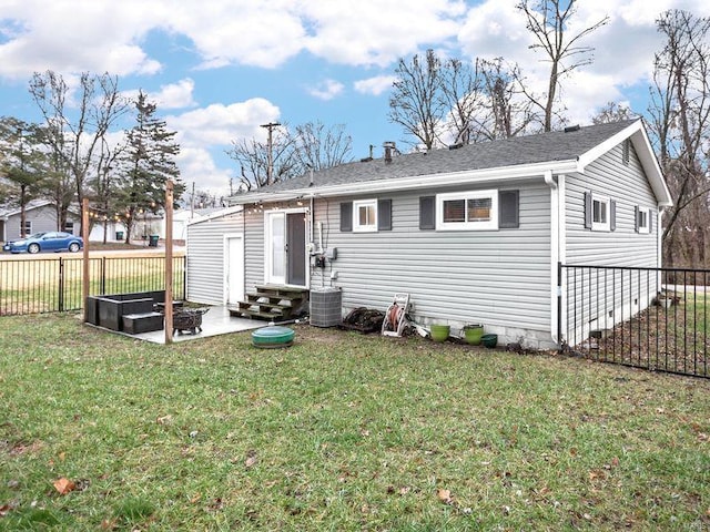 rear view of house with central AC unit, a yard, and a patio