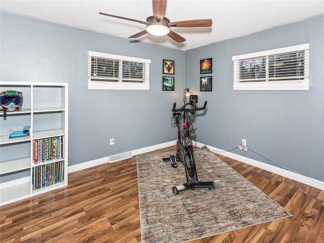 exercise room featuring ceiling fan and dark wood-type flooring