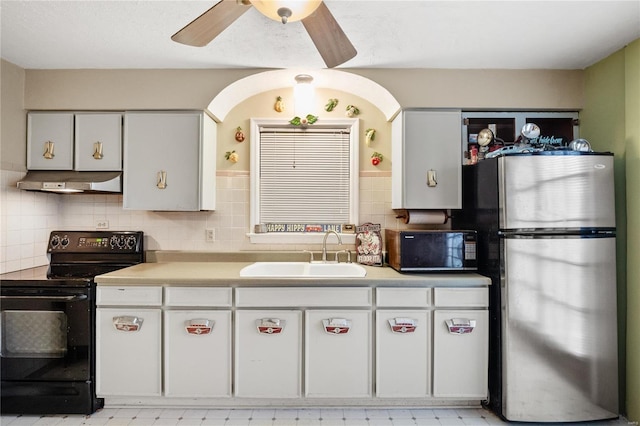 kitchen with black appliances, white cabinets, sink, decorative backsplash, and ceiling fan