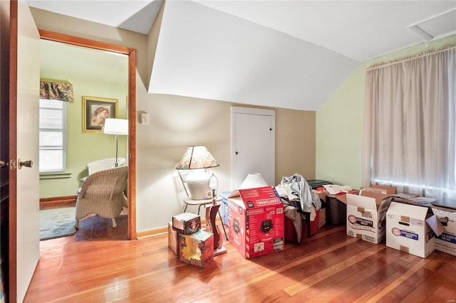 interior space with hardwood / wood-style flooring and vaulted ceiling