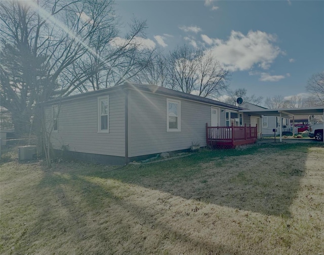 exterior space with a deck, a yard, and central AC