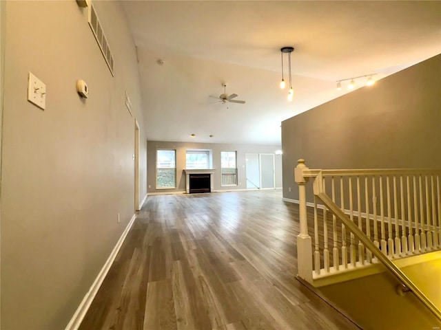 unfurnished living room featuring hardwood / wood-style floors, ceiling fan, and lofted ceiling