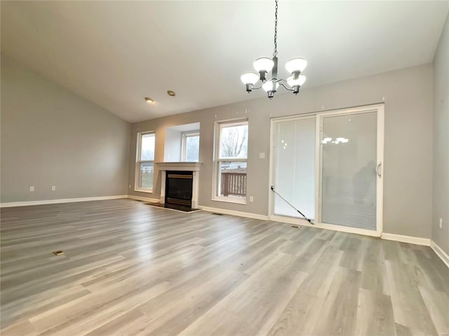 unfurnished living room featuring a notable chandelier and light hardwood / wood-style flooring