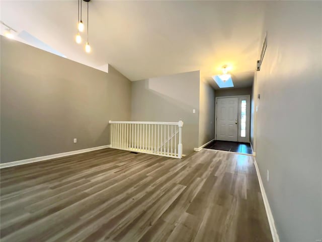 bonus room featuring lofted ceiling with skylight and dark hardwood / wood-style floors