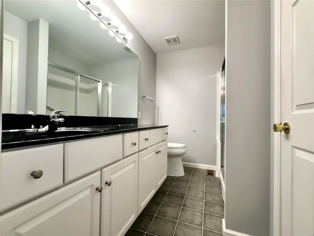 bathroom with tile patterned flooring, vanity, toilet, and walk in shower