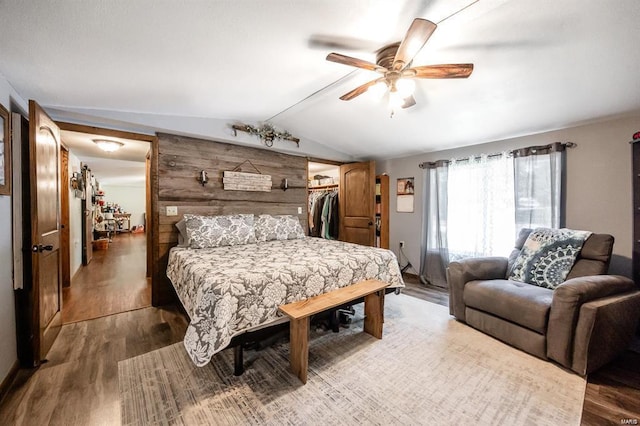 bedroom featuring vaulted ceiling, ceiling fan, wood-type flooring, a spacious closet, and a closet