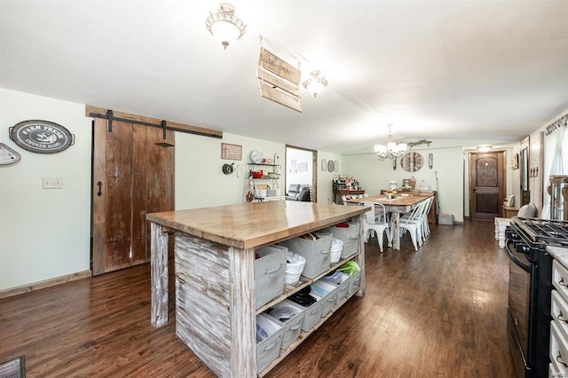 kitchen featuring wood counters, dark hardwood / wood-style flooring, gas stove, a barn door, and white cabinets