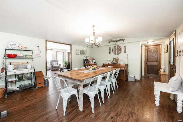 dining space featuring dark wood-type flooring, lofted ceiling, and a notable chandelier