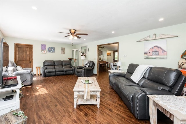 living room with dark hardwood / wood-style flooring and ceiling fan