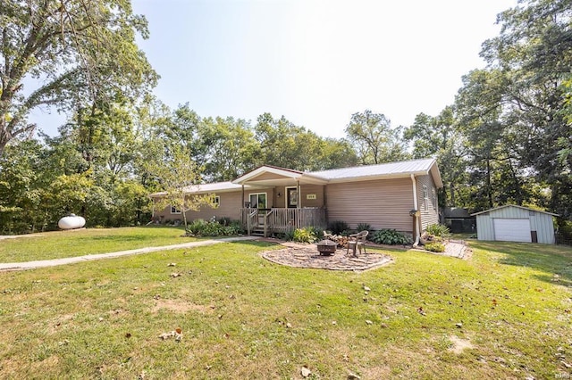 ranch-style home with an outbuilding, covered porch, an outdoor fire pit, and a front yard