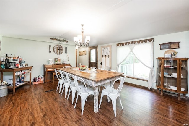 dining area featuring dark hardwood / wood-style flooring, lofted ceiling, and an inviting chandelier