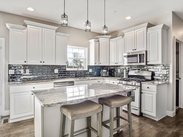 kitchen with a center island, stainless steel appliances, and white cabinetry