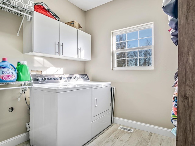 washroom featuring light hardwood / wood-style floors, cabinets, and independent washer and dryer